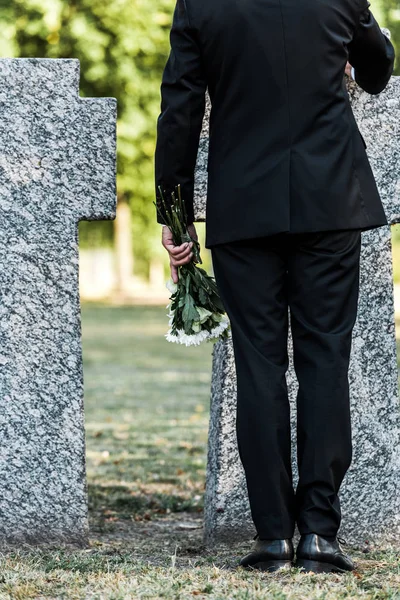 Vista Cortada Homem Sênior Segurando Flores Perto Túmulos — Fotografia de Stock