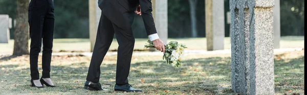 Panoramische Foto Van Man Putting Bloemen Buurt Van Grafstenen Vrouw — Stockfoto