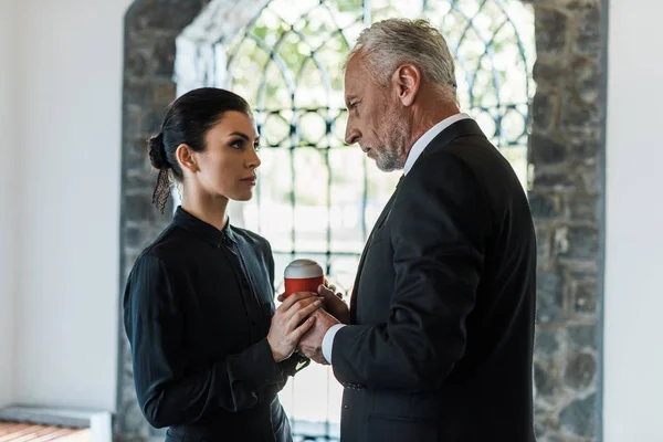 Upset Woman Looking Senior Man While Holding Mortuary Urn — Stock Photo, Image