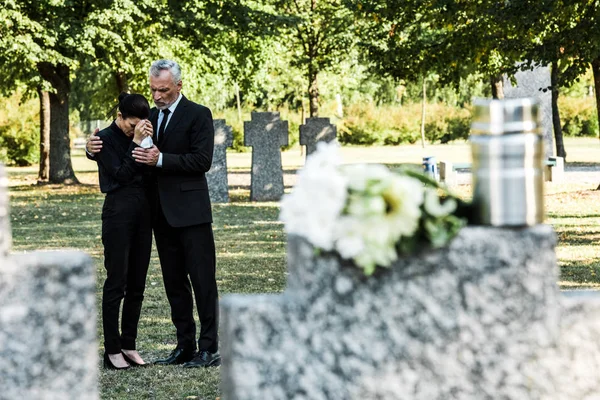 墓地で動揺した先輩男性の近くに悲しい女性の選択的な焦点 — ストック写真