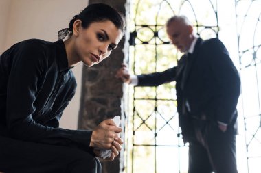 mendil tutan ve erkeğin yanında kameraya bakan güzel kadının seçici odak noktası 