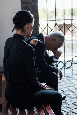 sinirli yaşlı adam yakın bankta oturan kadının seçici odak 