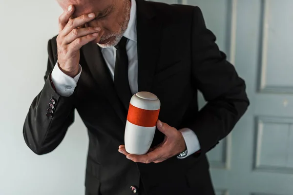 Upprörd Senior Man Röra Ansiktet Medan Håller Bårhus Urn — Stockfoto