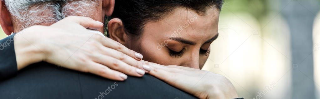 panoramic shot of woman hugging senior man 