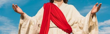 panoramic shot of jesus with outstretched hands against blue sky  clipart