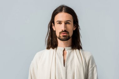 Yakışıklı sakallı adam gri renkli kameraya bakıyor. 