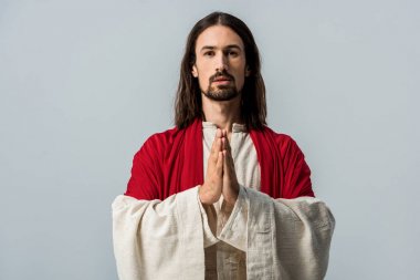 bearded man standing with praying hands isolated on grey  clipart