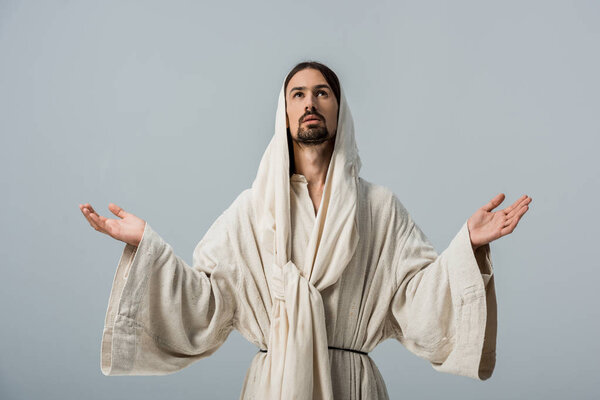 religious man in jesus robe with hood and outstretched hands isolated on grey