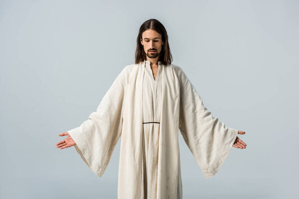 man in jesus robe standing with outstretched hands isolated on grey