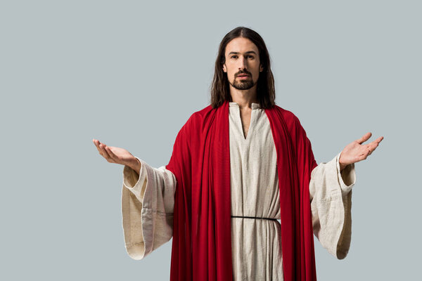 religious man looking at camera while standing with outstretched hands isolated on grey