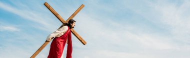 panoramic shot of bearded man walking with wooden cross  clipart