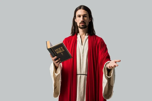 Hombre Guapo Gesticulando Sosteniendo Sagrada Biblia Aislada Gris — Foto de Stock