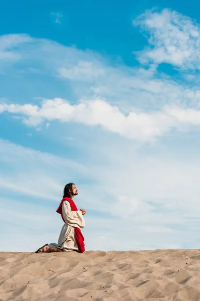 Man Praying Knees Clenched Hands Desert Wavy Sand — Stock Photo, Image