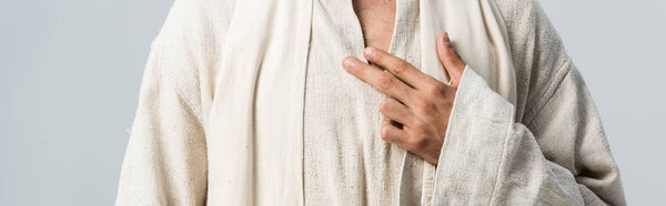 panoramic shot of man with hand on chest standing isolated on grey 