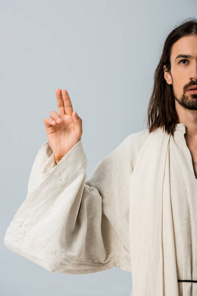 cropped view of bearded man in jesus robe gesturing isolated on grey 