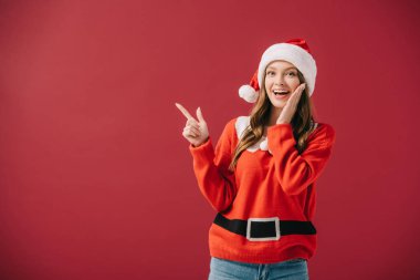 kırmızı izole parmak ile işaret santa şapka ve kazak çekici kadın 