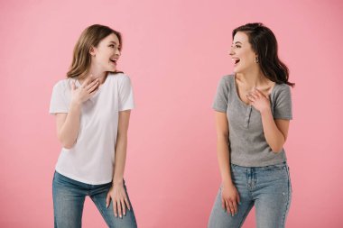 pembe izole birbirlerine bakarak t-shirt çekici ve gülümseyen kadınlar