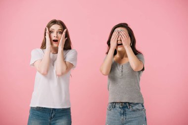 pembe izole kamera bakarak t-shirt çekici ve korkmuş kadınlar