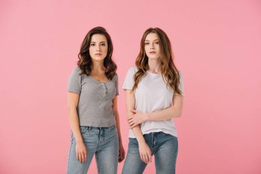 attractive women in t-shirts looking at camera isolated on pink clipart