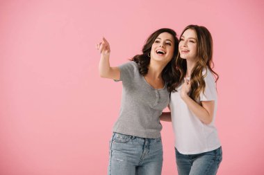 pembe izole parmak ile işaret t-shirt çekici ve gülümseyen kadınlar