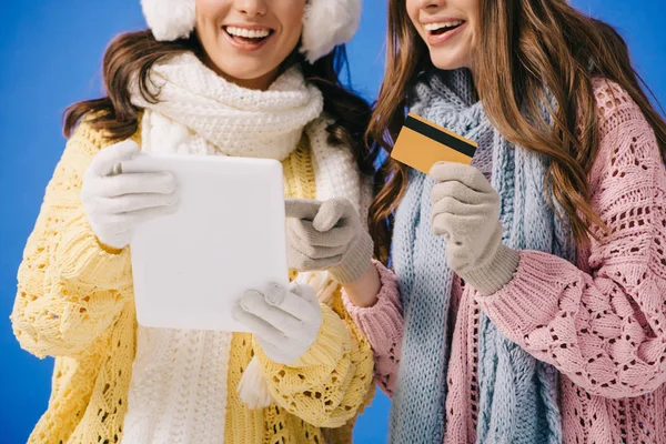 穿着毛衣和围巾的微笑妇女拿着数码平板电脑和信用卡在蓝色上 — 图库照片
