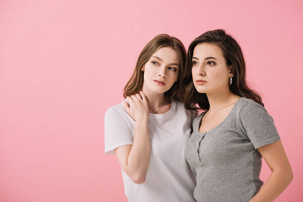 attractive women in t-shirts looking away isolated on pink