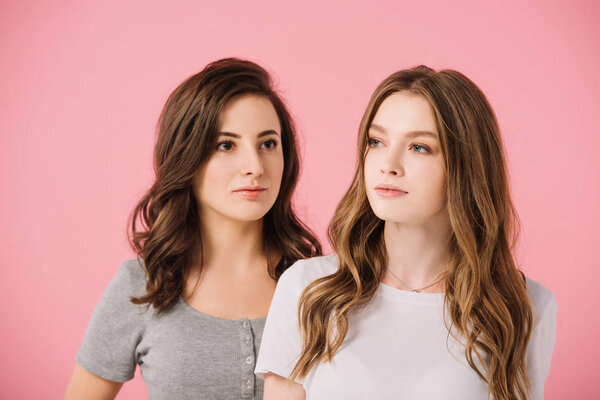 attractive women in t-shirts looking away isolated on pink