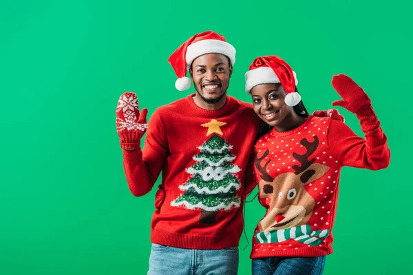 Афроамериканець Пара Червоних Різдвяних Светрів Санта Шапки Розмахуючи Руками Дивлячись — стокове фото
