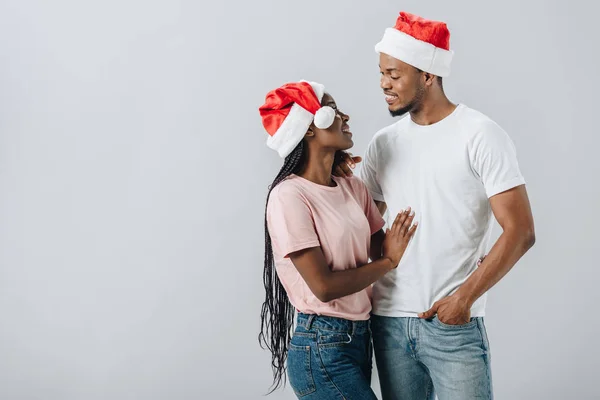 Pareja Afroamericana Sombreros Santa Claus Mirándose Aislados Gris — Foto de Stock