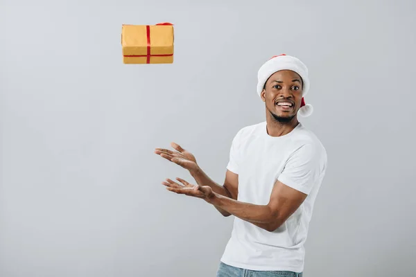 African American Man Santa Hoed Gooien Gift Box Geïsoleerd Grijs — Stockfoto