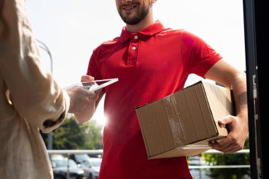 teslimat adam tutan paket ve kadına dijital tablet veren kırpılmış görünümü 