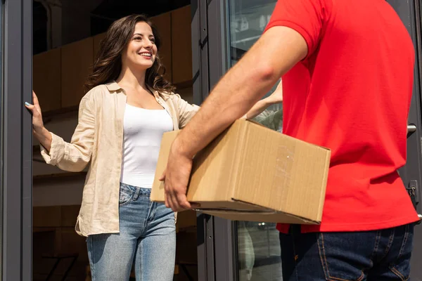 Ausgeschnittener Blick Auf Liefermann Der Schachtel Neben Fröhlicher Frau Hält — Stockfoto