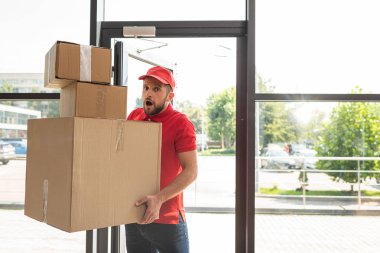 kameraya bakarken karton kutular tutan şok ve sakallı adam 