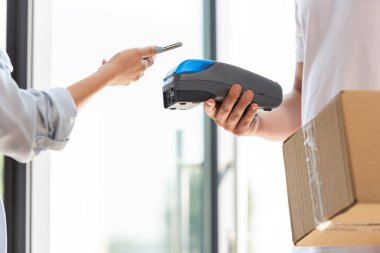 akıllı telefon ile kadın yakın ödeme terminali tutan teslimat adam kırpılmış görünümü 