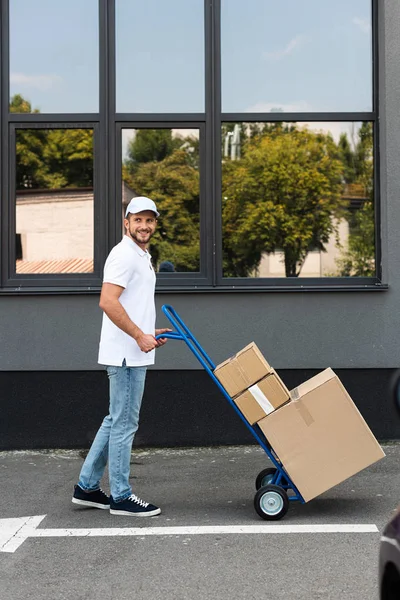 Happy Bearded Delivery Man Standing Delivery Cart Building — Stock Photo, Image