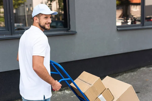 Smiling Bearded Delivery Man Standing Delivery Cart Building — Stock Photo, Image