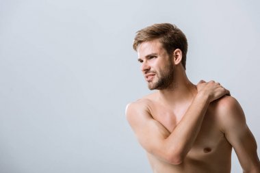 omzunda ağrı ile gömleksiz sakallı adam gri izole