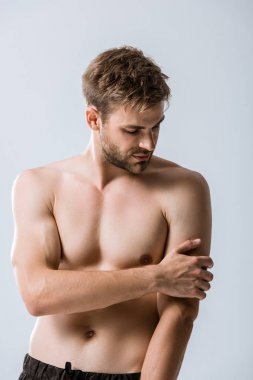 gri izole kol ağrısı ile gömleksiz kaslı adam