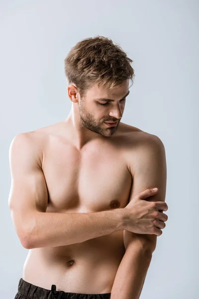 无衬衫肌肉男子与疼痛的手臂隔离在灰色 — 图库照片