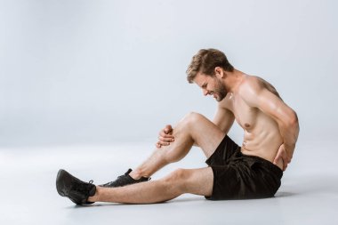 gri alt sırt ağrısı ile gömleksiz sakallı sporcu