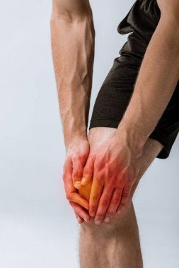 gri izole diz ağrısı ile sporcunun kırpılmış görünümü