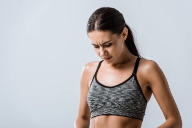 memnun olmayan çekici sporcu gri izole aşağı bakıyor