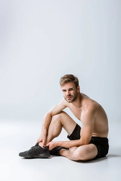 Hemdloser Bärtiger Sportler Mit Knöchelschmerzen Auf Grau — Stockfoto