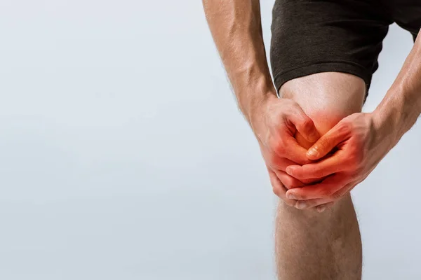 灰色で隔離された膝の痛みを持つスポーツマンのトリミングされたビュー — ストック写真