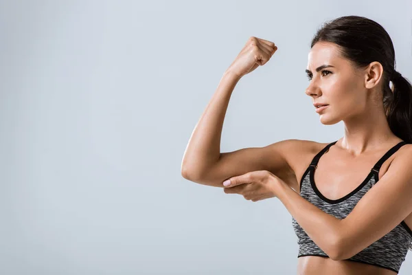 Attraktive Brünette Sportlerin Berührt Muskeln Isoliert Auf Grau — Stockfoto