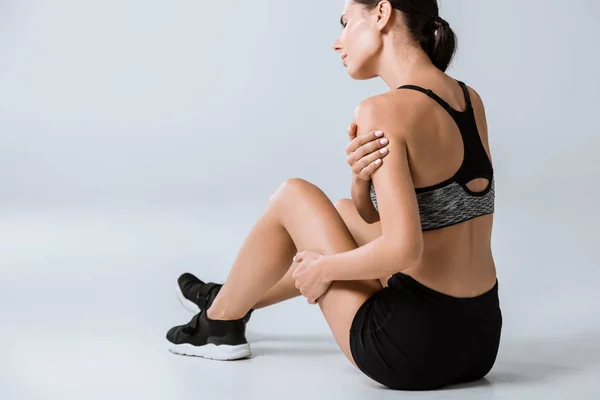 Brünette Sportlerin Sportbekleidung Mit Schulterschmerzen Auf Grau — Stockfoto