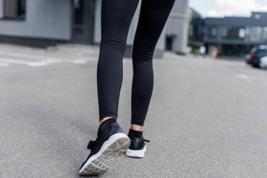 sokakta siyah spor ayakkabılı sporcunun kırpılmış görünümü