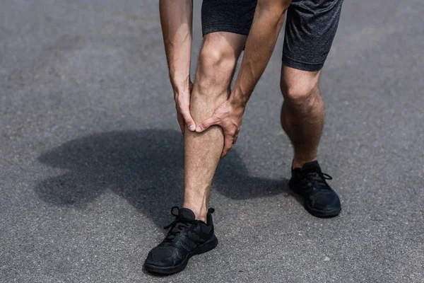 Sokakta Bacak Ağrısı Ile Siyah Spor Ayakkabı Sporcu Kısmi Görünümü — Stok fotoğraf