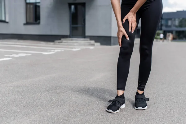 Teilbild Einer Sportlerin Schwarzen Turnschuhen Mit Beinschmerzen Auf Der Straße — Stockfoto
