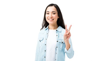 Kot gömlekli çekici ve gülümseyen Asyalı kadın beyaz üzerinde barış işareti gösteriyor. 